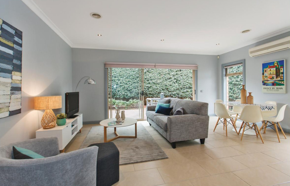 Photo of a mid-sized contemporary open concept living room in Melbourne with grey walls, ceramic floors, a freestanding tv and beige floor.
