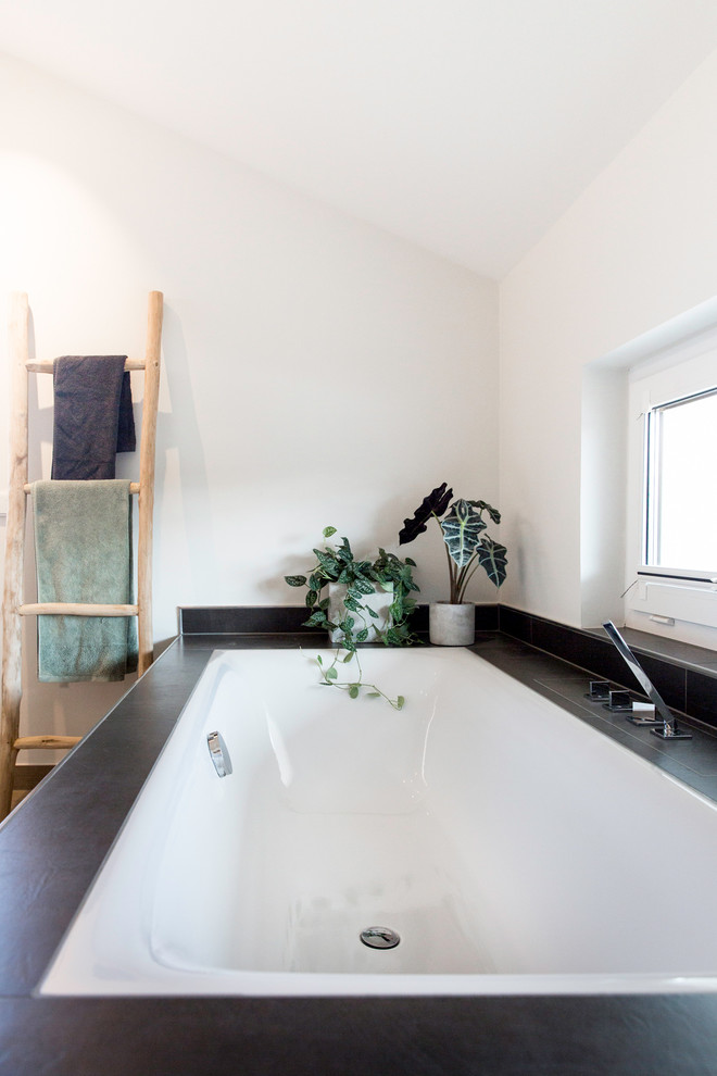 Bild på ett mellanstort funkis badrum, med ett platsbyggt badkar, keramikplattor, vita väggar och cementgolv