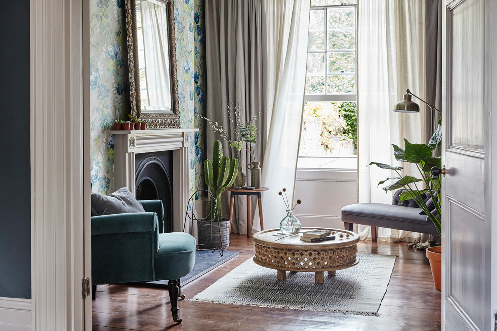 Classic formal enclosed living room in London with white walls, medium hardwood flooring, a standard fireplace, brown floors and feature lighting.