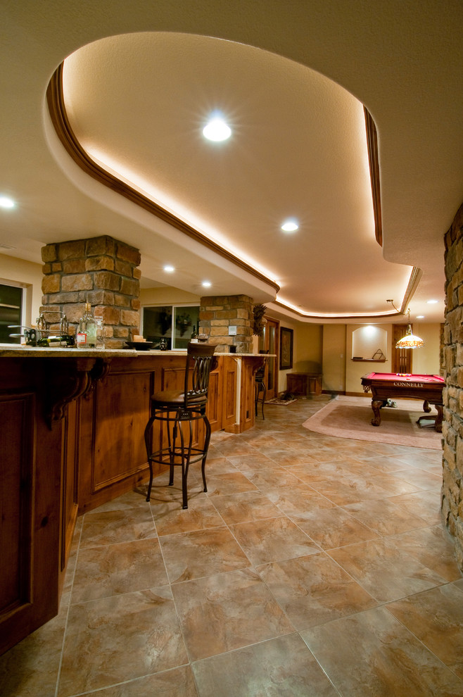 This is an example of an expansive country walk-out basement in Denver with yellow walls, carpet and a standard fireplace.