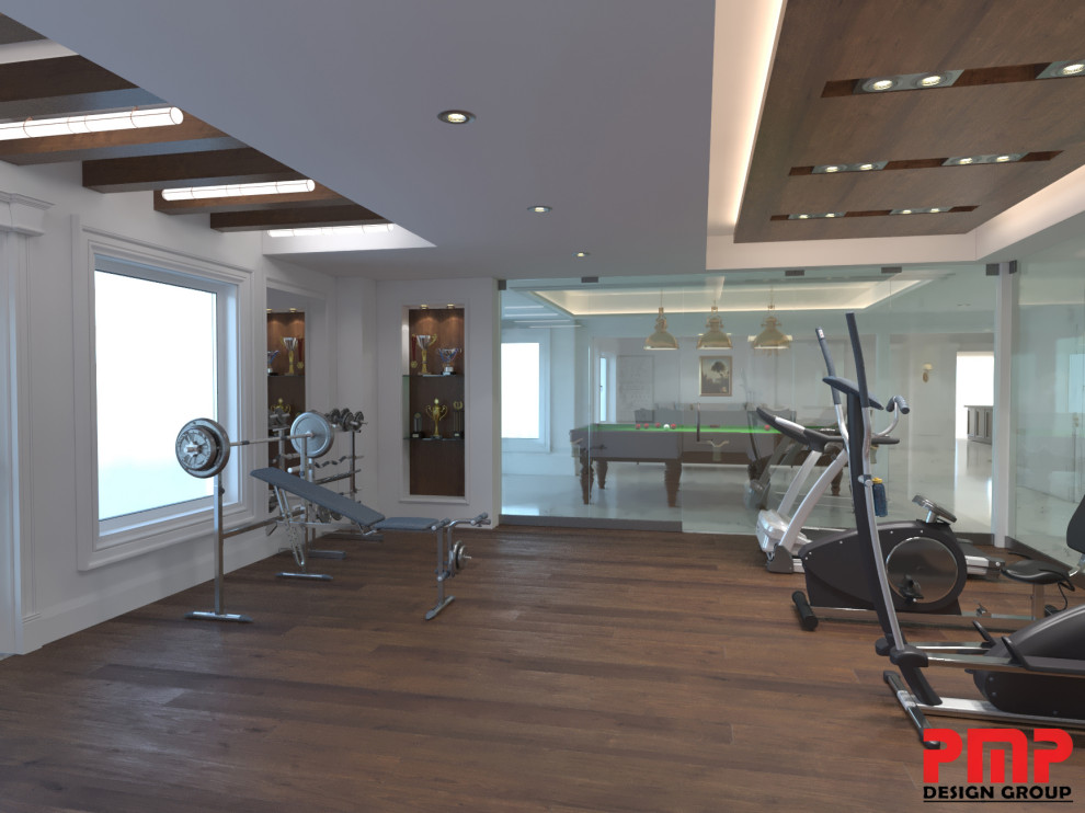 This is an example of a large traditional home weight room in Toronto with medium hardwood floors, brown floor and white walls.