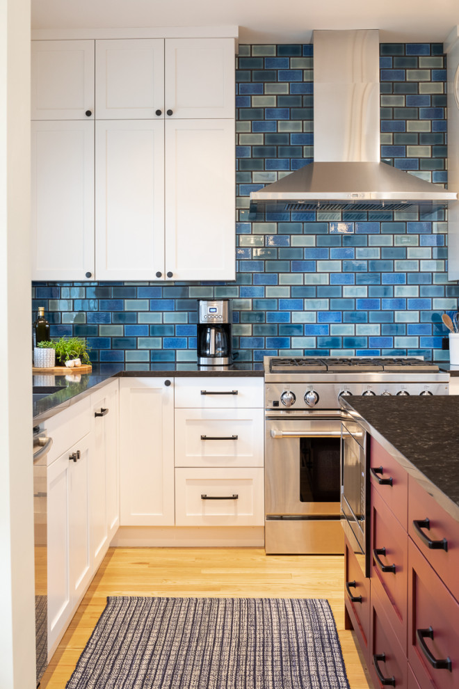 Mid-sized transitional l-shaped eat-in kitchen in Seattle with an undermount sink, shaker cabinets, white cabinets, quartz benchtops, blue splashback, porcelain splashback, stainless steel appliances, light hardwood floors, with island, yellow floor and brown benchtop.