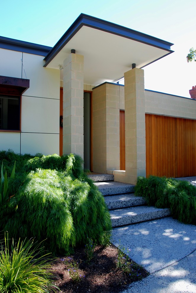 Inspiration for a contemporary two-storey beige house exterior in Melbourne with mixed siding and a flat roof.