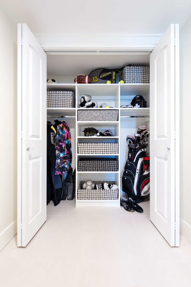 Small gender-neutral built-in wardrobe in Other with white cabinets, porcelain floors and white floor.