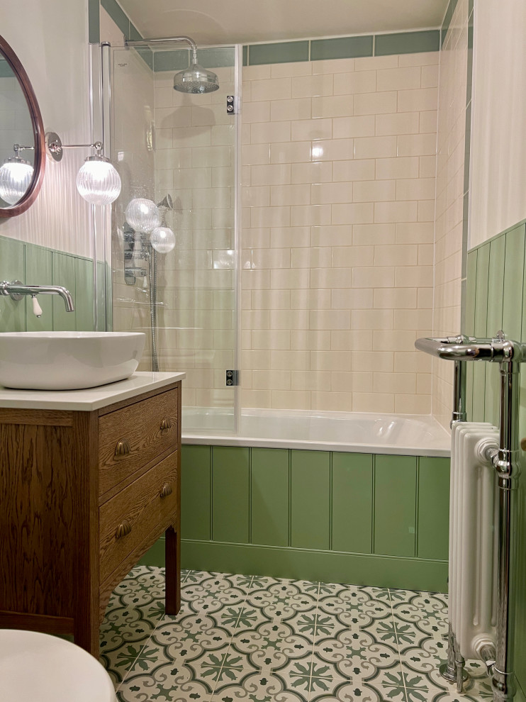 На фото: маленькая детская ванная комната в классическом стиле с плоскими фасадами, коричневыми фасадами, накладной ванной, душем над ванной, раздельным унитазом, зеленой плиткой, керамической плиткой, белыми стенами, полом из керамической плитки, мраморной столешницей, разноцветным полом, белой столешницей, тумбой под одну раковину, напольной тумбой и стенами из вагонки для на участке и в саду с