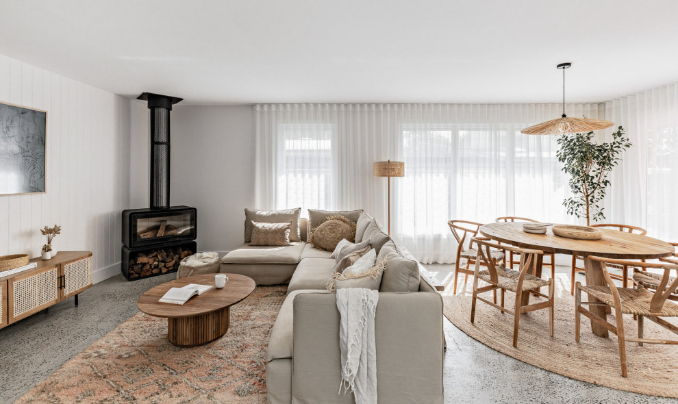 Mittelgroßes, Offenes Maritimes Wohnzimmer mit weißer Wandfarbe, Betonboden, Eckkamin, grauem Boden und Holzdielenwänden in Sydney