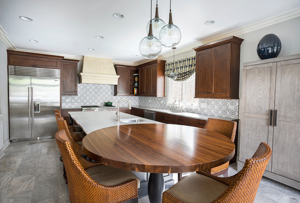 Large transitional l-shaped eat-in kitchen in Chicago with an undermount sink, recessed-panel cabinets, wood benchtops, stainless steel appliances, travertine floors, with island and dark wood cabinets.