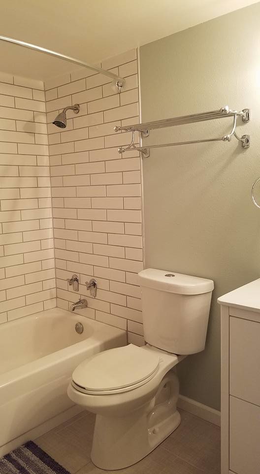 Alcove bathtub - mid-sized transitional 3/4 white tile and subway tile porcelain tile and beige floor alcove bathtub idea with flat-panel cabinets, white cabinets, a two-piece toilet, beige walls, an integrated sink, solid surface countertops and white countertops
