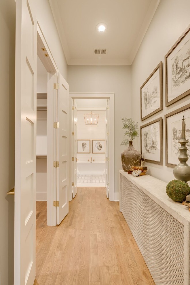 Inspiration for a mid-sized traditional hallway in Other with white walls, light hardwood floors and brown floor.