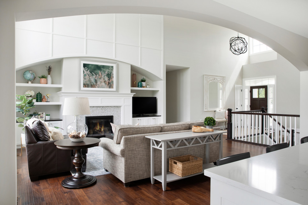 Design ideas for a mid-sized transitional open concept living room with grey walls, medium hardwood floors, a standard fireplace, a tile fireplace surround, a built-in media wall and brown floor.