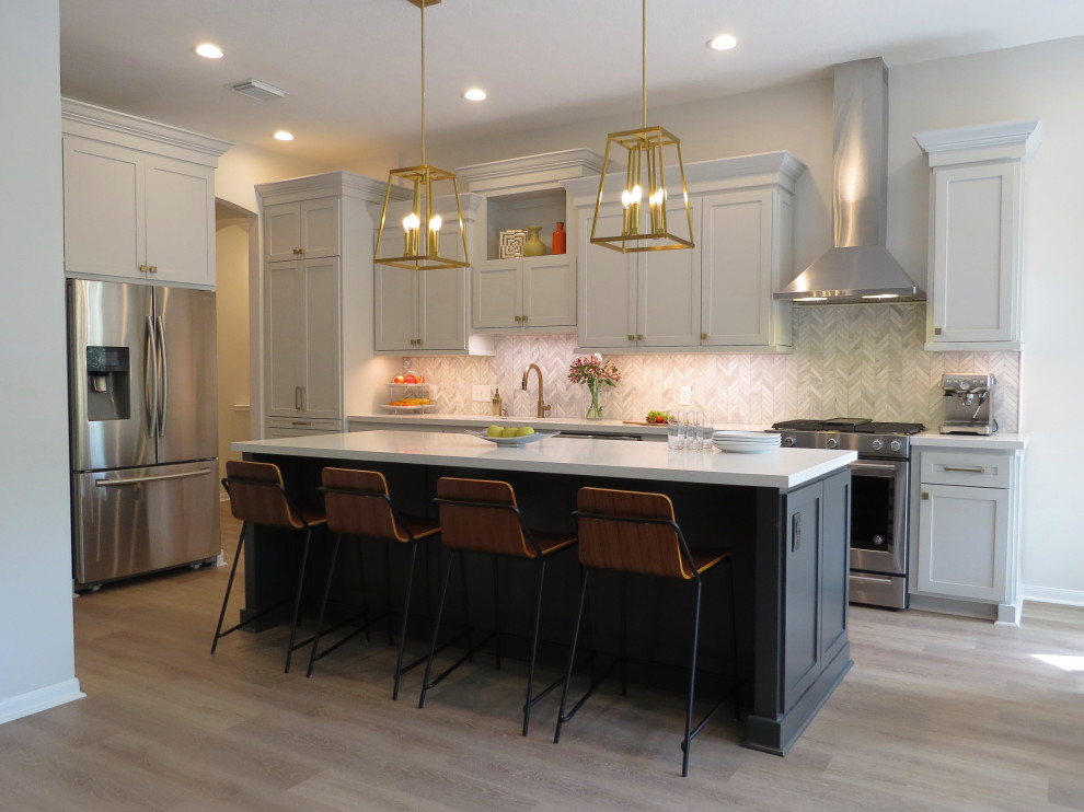 Inspiration for a mid-sized transitional l-shaped eat-in kitchen in Houston with shaker cabinets, grey cabinets, quartz benchtops, white splashback, marble splashback, stainless steel appliances, vinyl floors, with island, beige floor, white benchtop and an undermount sink.