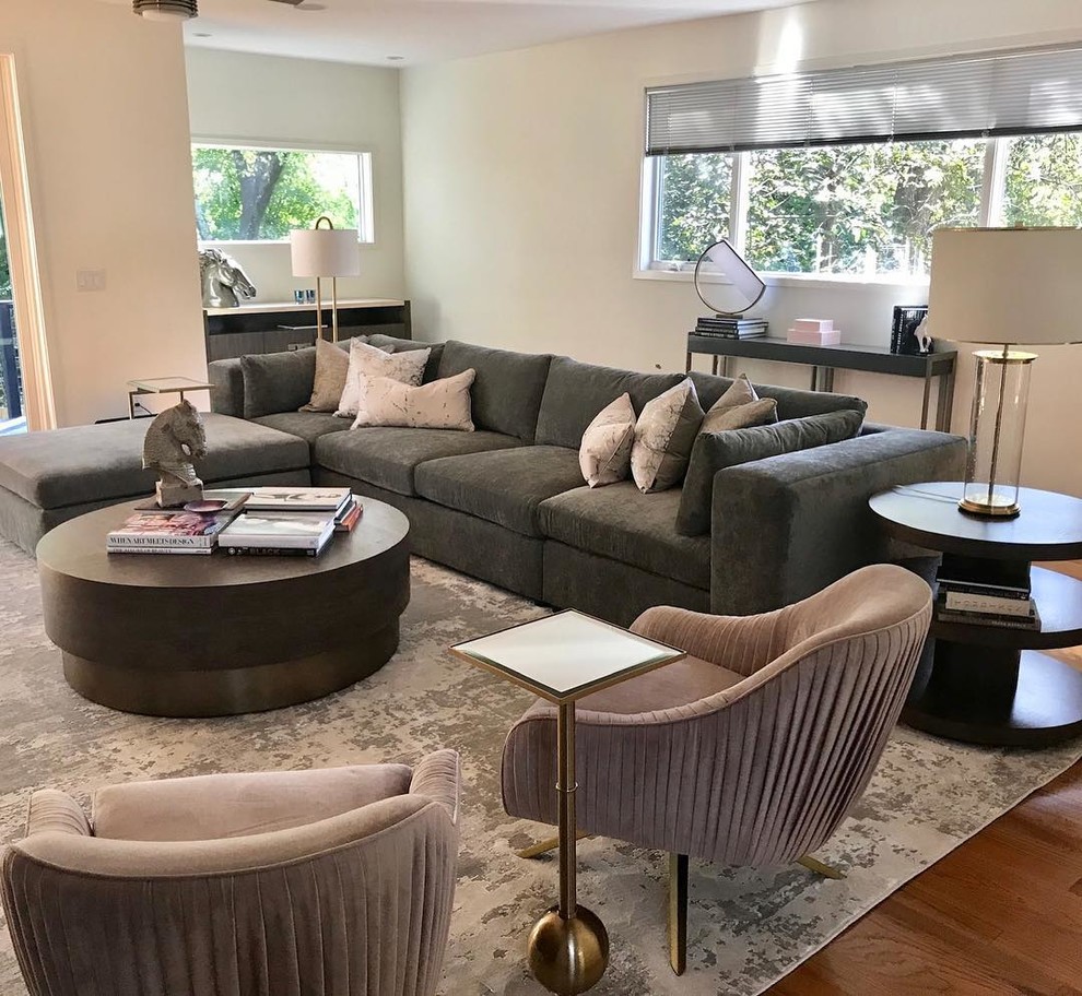 This is an example of a large contemporary open concept family room in Atlanta with beige walls, light hardwood floors, a built-in media wall and brown floor.