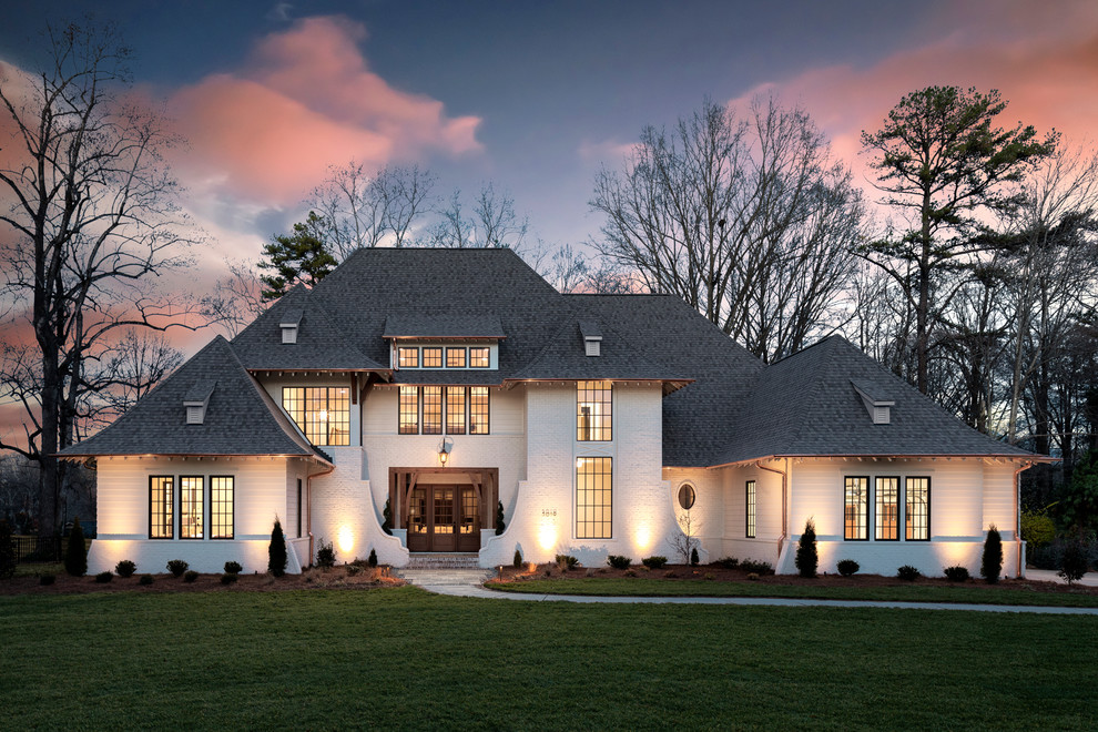 Photo of an expansive traditional two-storey brick white house exterior in Charlotte with a gable roof and a shingle roof.
