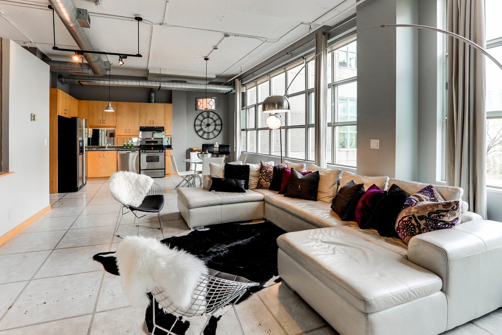 Photo of a large industrial loft-style living room in Toronto with grey walls, concrete floors, no fireplace, no tv and white floor.