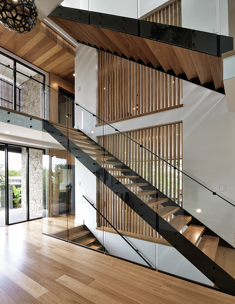 Design ideas for a contemporary wood straight staircase in Brisbane with open risers and glass railing.