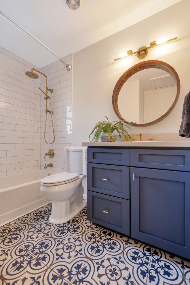 This is an example of a small transitional 3/4 bathroom in Phoenix with shaker cabinets, blue cabinets, an alcove tub, a shower/bathtub combo, white tile, subway tile, grey walls, porcelain floors, an undermount sink, engineered quartz benchtops, blue floor, a shower curtain, white benchtops, a single vanity and a built-in vanity.