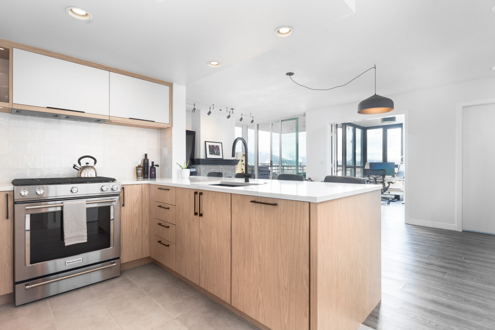 Small contemporary u-shaped eat-in kitchen in Vancouver with an undermount sink, flat-panel cabinets, light wood cabinets, quartzite benchtops, beige splashback, ceramic splashback, stainless steel appliances, porcelain floors and beige floor.