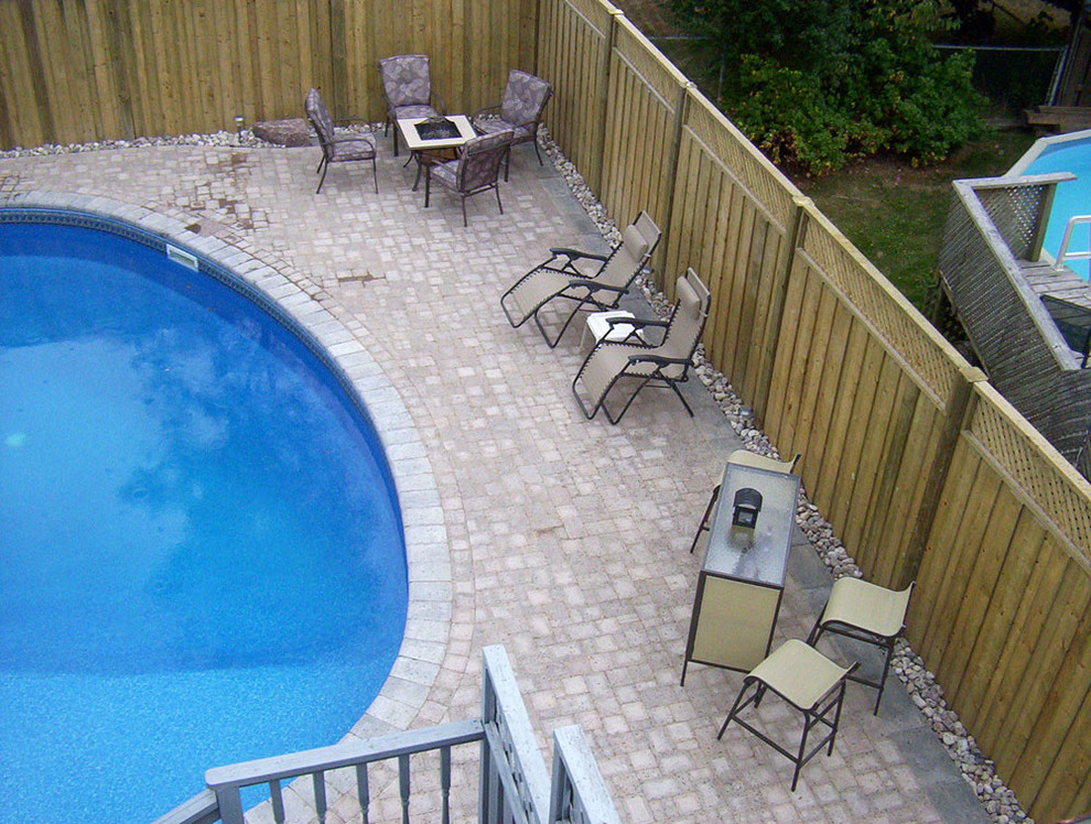 Pool - mid-sized backyard concrete paver and freeform pool idea
