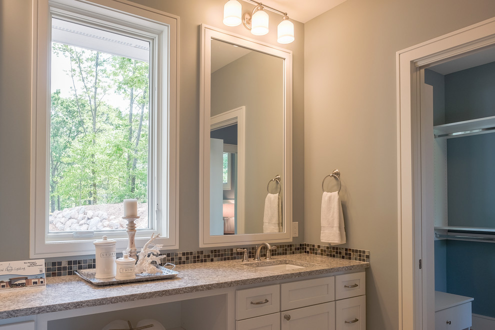Inspiration for a large arts and crafts master bathroom in Grand Rapids with recessed-panel cabinets, white cabinets, an alcove shower, brown tile, porcelain tile, grey walls, porcelain floors, an undermount sink, granite benchtops, beige floor and a hinged shower door.