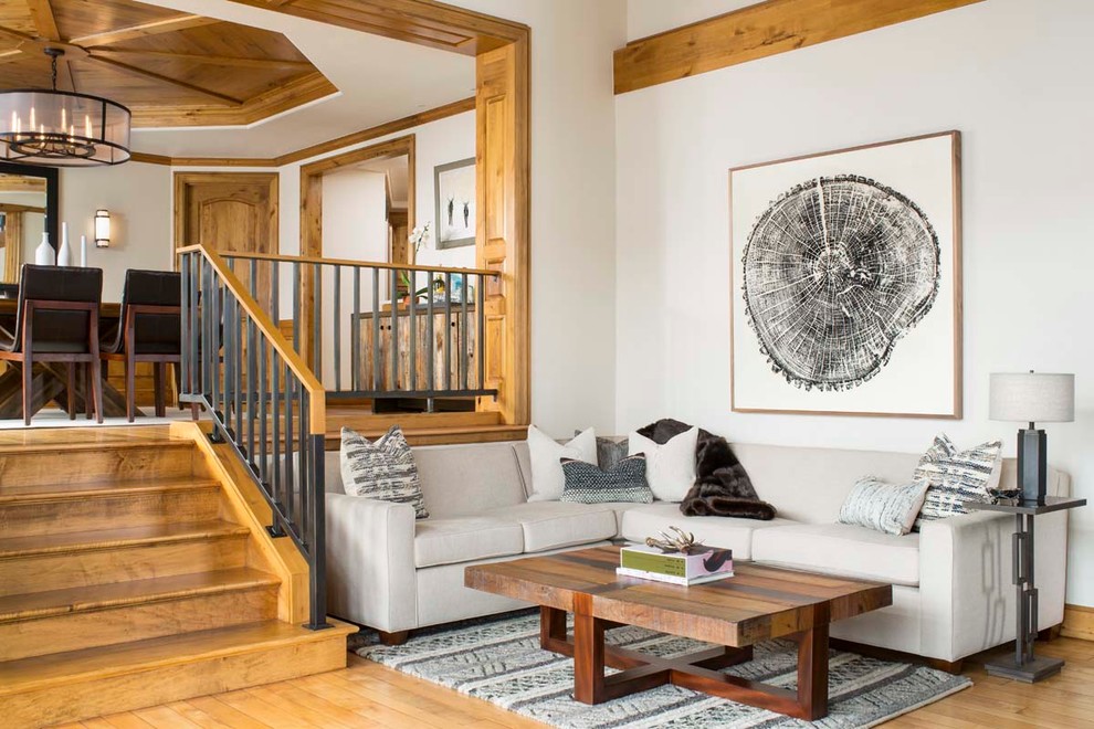 Huge mountain style medium tone wood floor family room photo in Denver with white walls and a wall-mounted tv