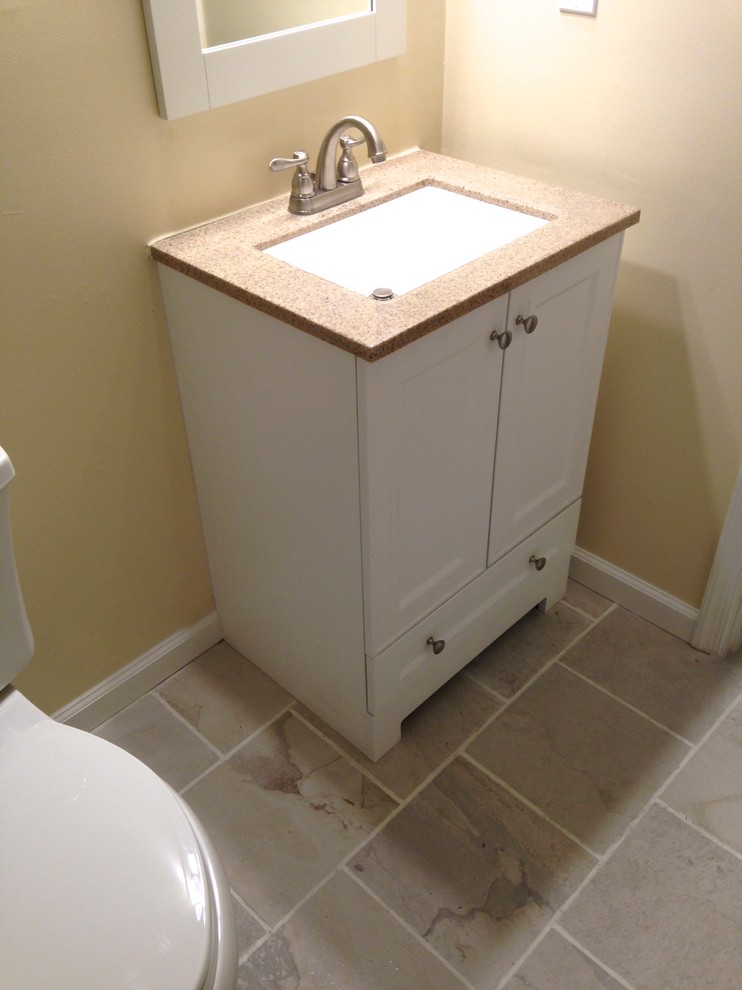 Small transitional 3/4 white tile and porcelain tile porcelain tile alcove bathtub photo with an integrated sink, flat-panel cabinets, white cabinets, solid surface countertops, a one-piece toilet and beige walls