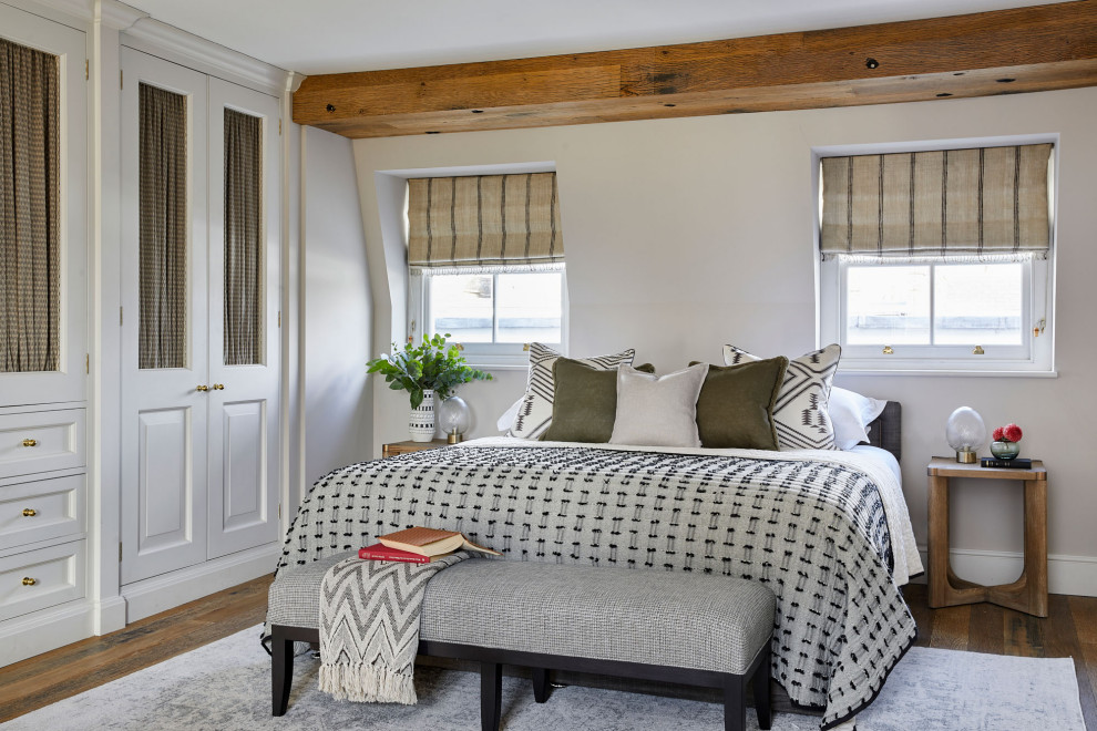 Foto de habitación de invitados tradicional renovada sin chimenea con paredes blancas, suelo de madera en tonos medios, suelo marrón y vigas vistas