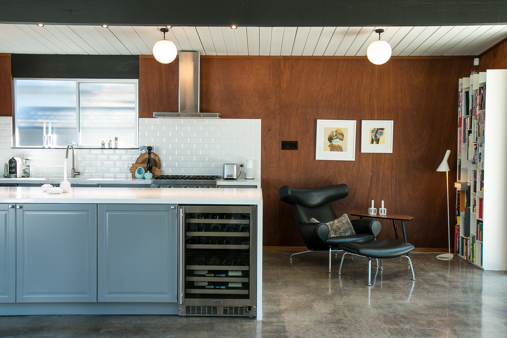 Design ideas for a mid-sized midcentury single-wall eat-in kitchen in San Francisco with an integrated sink, recessed-panel cabinets, grey cabinets, quartzite benchtops, white splashback, ceramic splashback, stainless steel appliances, concrete floors and with island.
