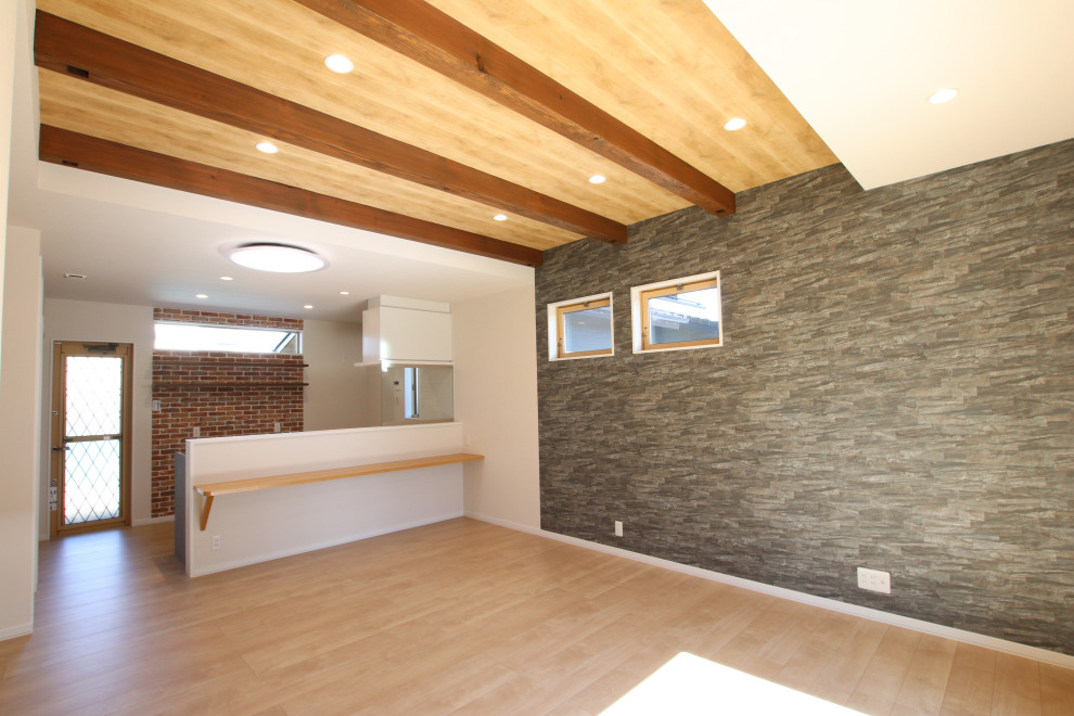 Exemple d'un salon moderne ouvert avec un sol en contreplaqué, poutres apparentes et du papier peint.
