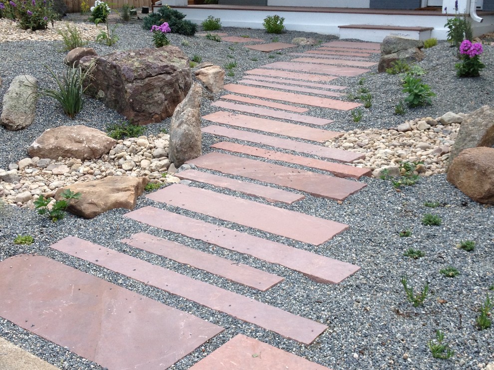 Inspiration for a mid-sized modern front yard partial sun xeriscape in Denver with natural stone pavers.