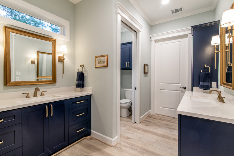 Bild på ett stort rustikt vit vitt en-suite badrum, med skåp i shakerstil, blå skåp, en kantlös dusch, en toalettstol med separat cisternkåpa, gröna väggar, laminatgolv, ett undermonterad handfat, granitbänkskiva, grått golv och med dusch som är öppen