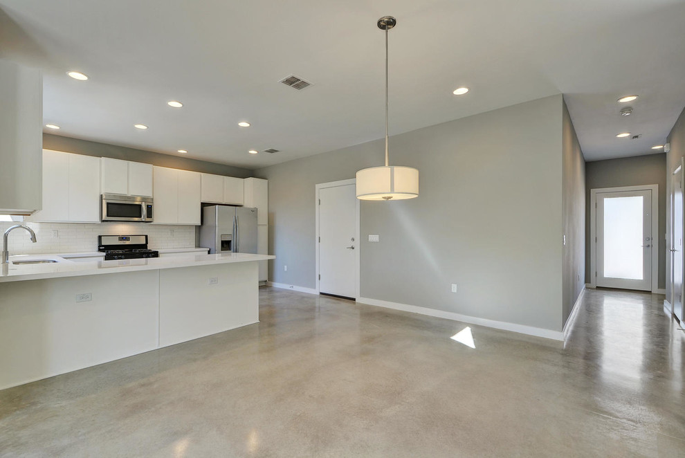 This is an example of a mid-sized modern kitchen/dining combo in Austin with concrete floors.