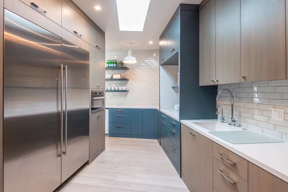 Inspiration for a large modern galley kitchen pantry in Salt Lake City with an undermount sink, blue cabinets, quartzite benchtops, white splashback, stainless steel appliances, medium hardwood floors, no island, white floor and white benchtop.
