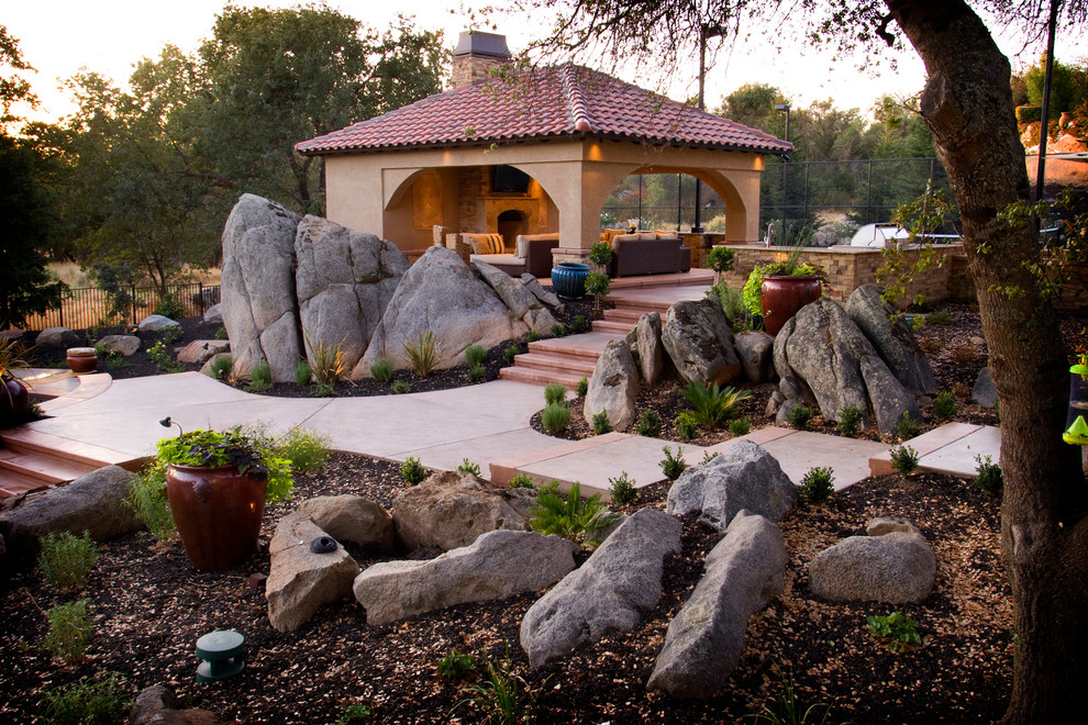 Mediterranean backyard garden in Sacramento with with rock feature.