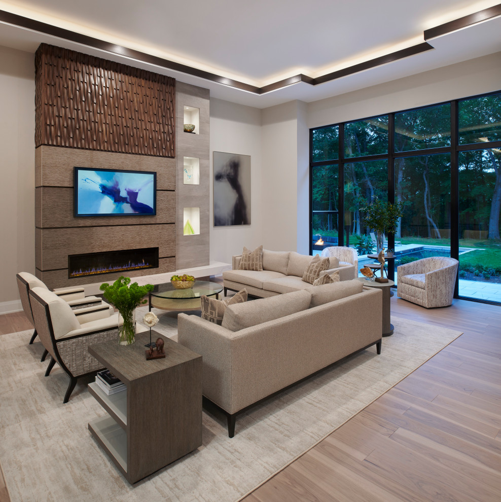Inspiration for a large contemporary open concept light wood floor, brown floor and coffered ceiling family room remodel in Detroit with beige walls, a standard fireplace, a tile fireplace and a media wall