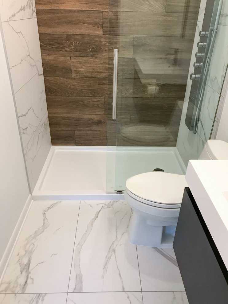 Photo of a small modern 3/4 bathroom in Raleigh with flat-panel cabinets, black cabinets, an alcove shower, a one-piece toilet, porcelain tile, white walls, porcelain floors, an integrated sink, white floor, a sliding shower screen and white benchtops.