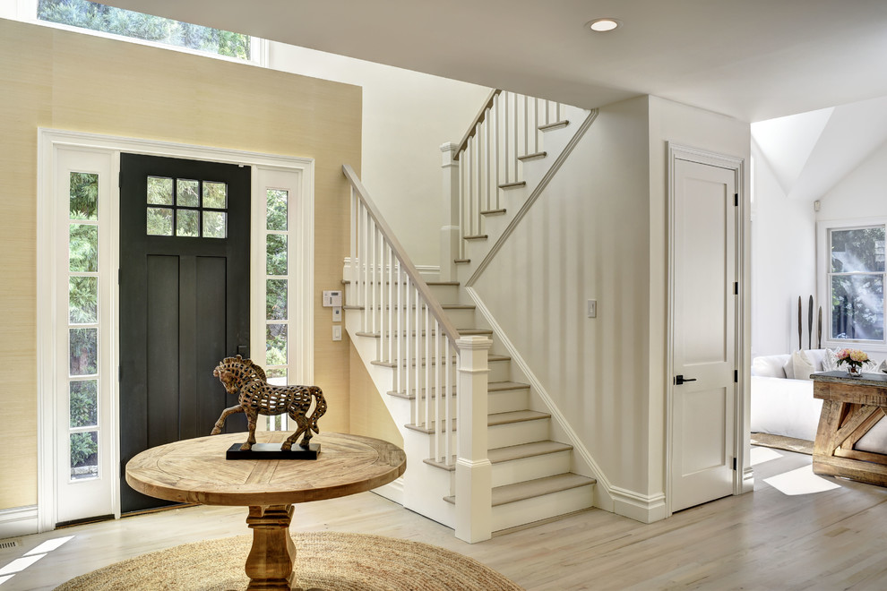 Inspiration for a beach style foyer in New York with beige walls, light hardwood floors, a single front door, a black front door and beige floor.