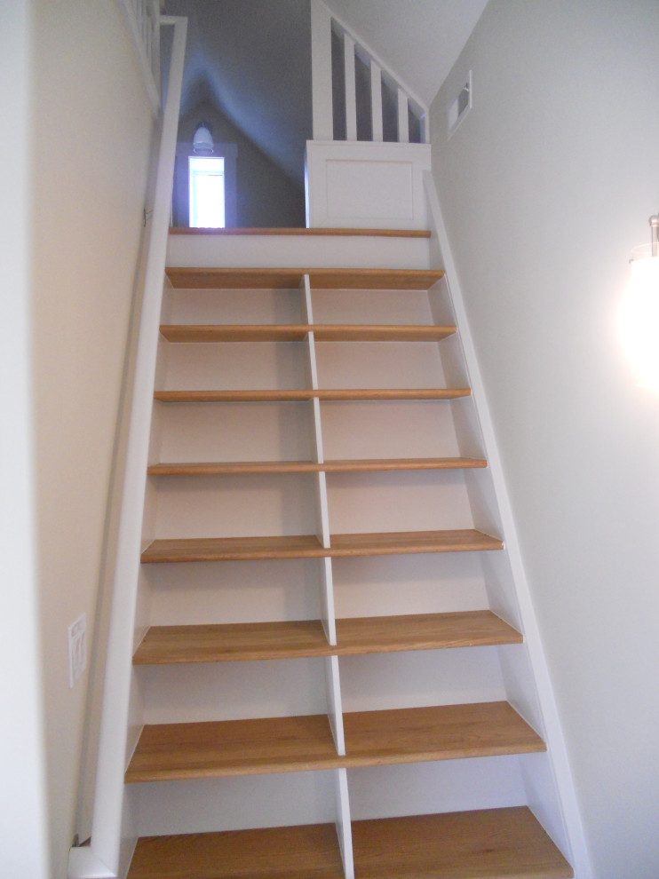 Photo of a mid-sized scandinavian wood straight staircase in Other with wood railing and open risers.