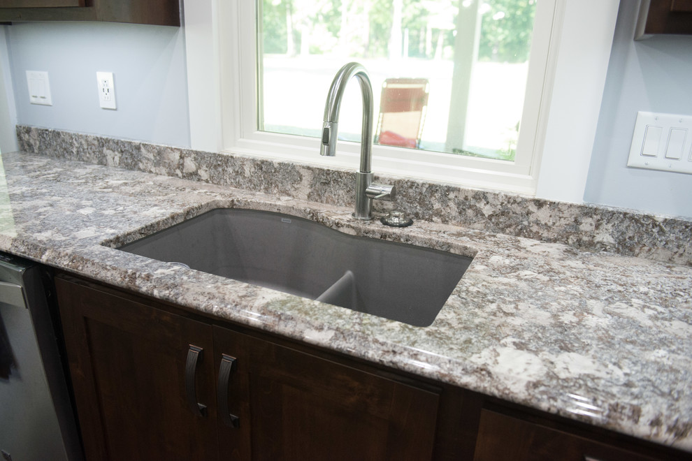 Transitional l-shaped open concept kitchen photo with an undermount sink, shaker cabinets, dark wood cabinets, granite countertops, stainless steel appliances, an island and multicolored countertops