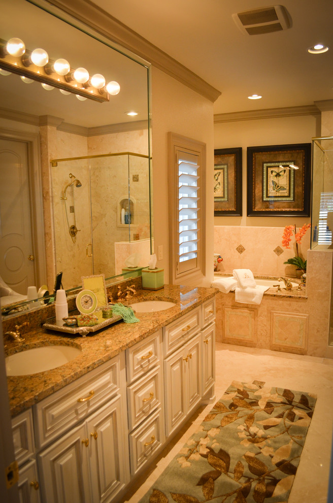 Design ideas for a mid-sized traditional master bathroom in New Orleans with beaded inset cabinets, white cabinets, a drop-in tub, a corner shower, beige tile, stone tile, beige walls, travertine floors, an undermount sink and granite benchtops.