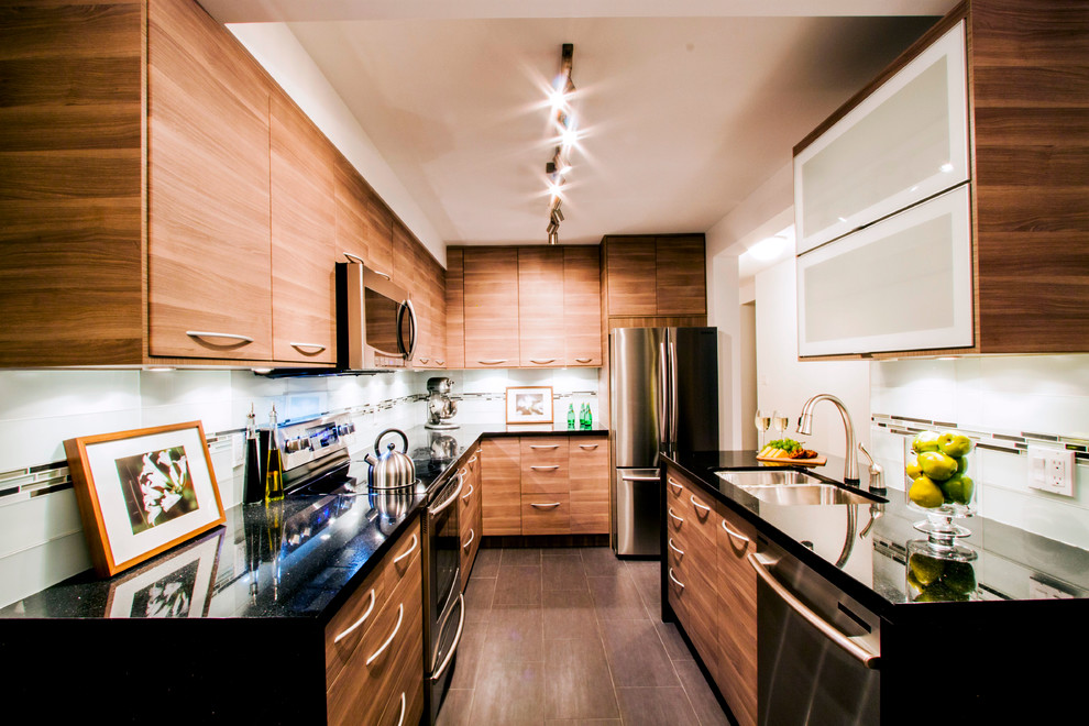 Photo of a small contemporary u-shaped separate kitchen in Vancouver with an undermount sink, flat-panel cabinets, medium wood cabinets, quartz benchtops, multi-coloured splashback, glass tile splashback, stainless steel appliances, porcelain floors and no island.