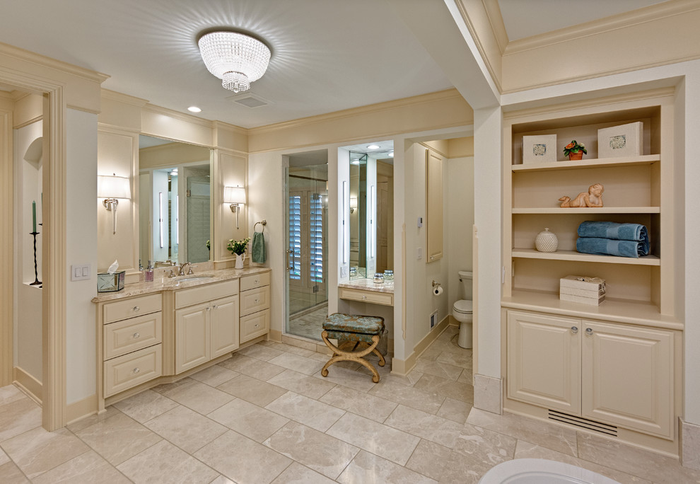 This is an example of a large traditional master bathroom in Minneapolis with raised-panel cabinets, a hot tub, an open shower, white tile, ceramic tile, white walls, porcelain floors, an undermount sink, granite benchtops and beige cabinets.