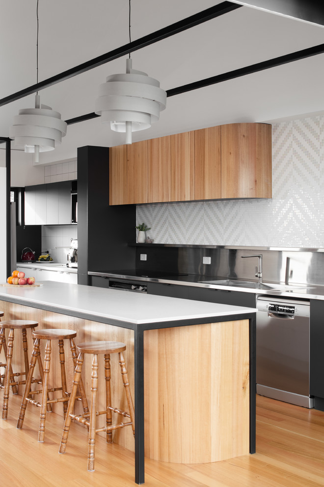 Design ideas for a contemporary galley kitchen in Hobart with an integrated sink, flat-panel cabinets, medium wood cabinets, stainless steel benchtops, white splashback, mosaic tile splashback, stainless steel appliances, medium hardwood floors, with island and brown floor.