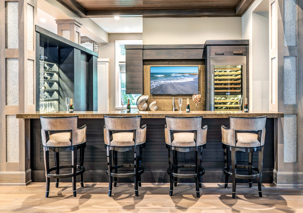 Photo of a transitional seated home bar in Miami with dark wood cabinets and light hardwood floors.