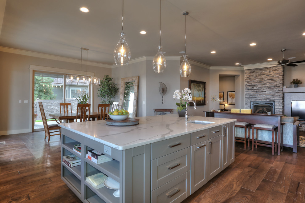 Example of a large transitional medium tone wood floor open concept kitchen design in Seattle with an undermount sink, recessed-panel cabinets, gray cabinets, quartz countertops and an island