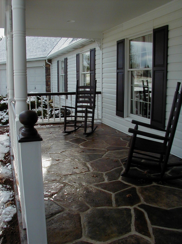 Photo of a mid-sized traditional front yard verandah in Philadelphia with stamped concrete and a roof extension.