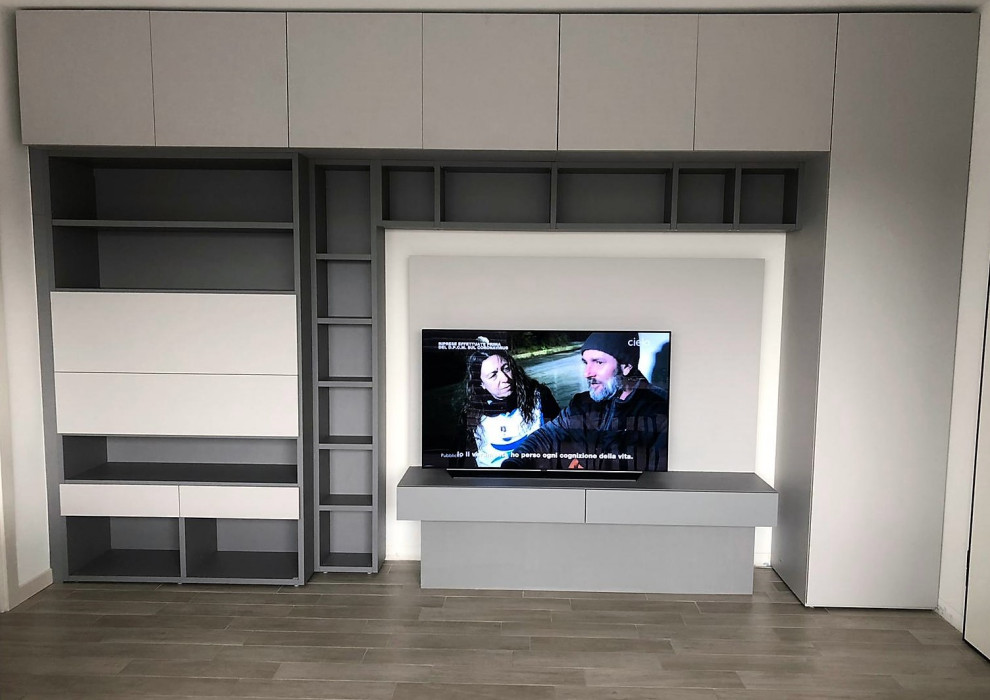 Moderne Bibliothek mit weißer Wandfarbe, Porzellan-Bodenfliesen, TV-Wand und grauem Boden in Sonstige