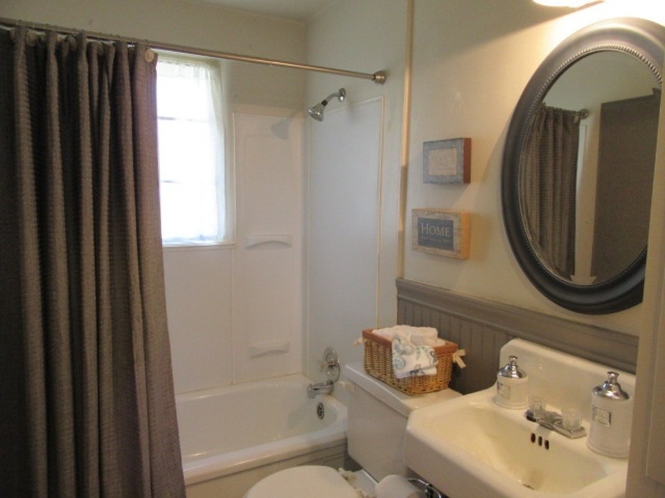 This is an example of a small country master bathroom in Portland with flat-panel cabinets, white cabinets, a one-piece toilet, grey walls, dark hardwood floors and a wall-mount sink.
