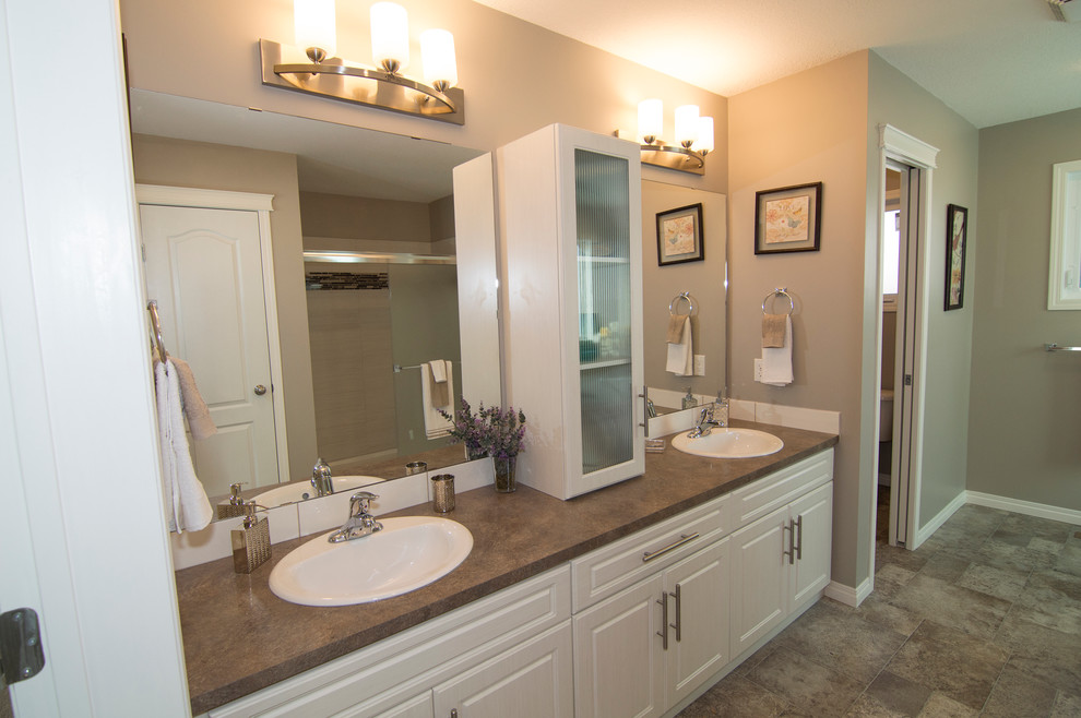 Inspiration for a large contemporary master bathroom in Calgary with a drop-in sink, raised-panel cabinets, white cabinets, laminate benchtops, a drop-in tub, an open shower, a one-piece toilet, yellow tile, subway tile, beige walls and linoleum floors.