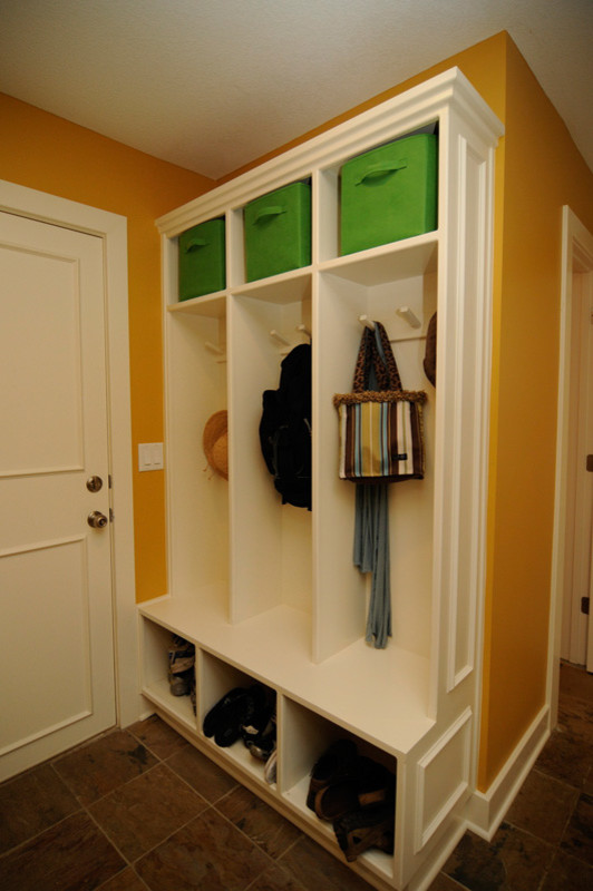 Design ideas for a small transitional mudroom in Kansas City with orange walls, laminate floors, a single front door, a white front door and brown floor.