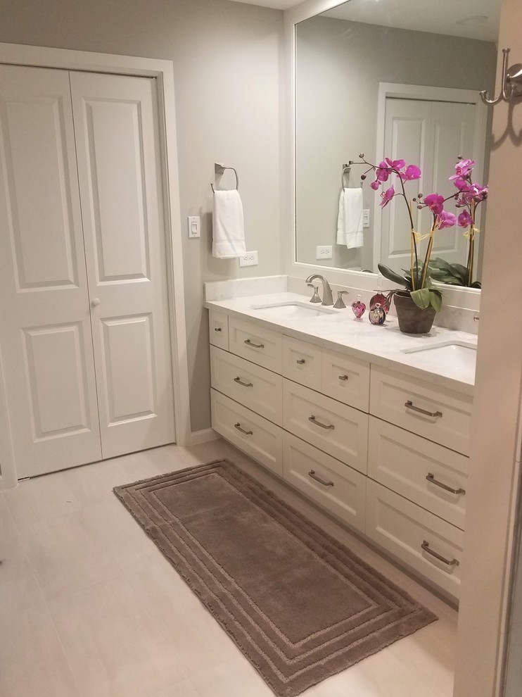 Design ideas for a large transitional master bathroom in Houston with recessed-panel cabinets, white cabinets, a curbless shower, a one-piece toilet, gray tile, porcelain tile, grey walls, porcelain floors, an undermount sink, engineered quartz benchtops, white floor and a hinged shower door.